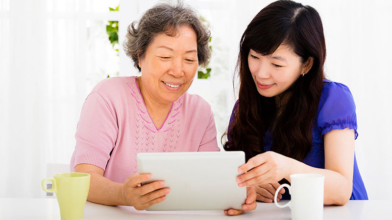 mom and daughter looking at tablet